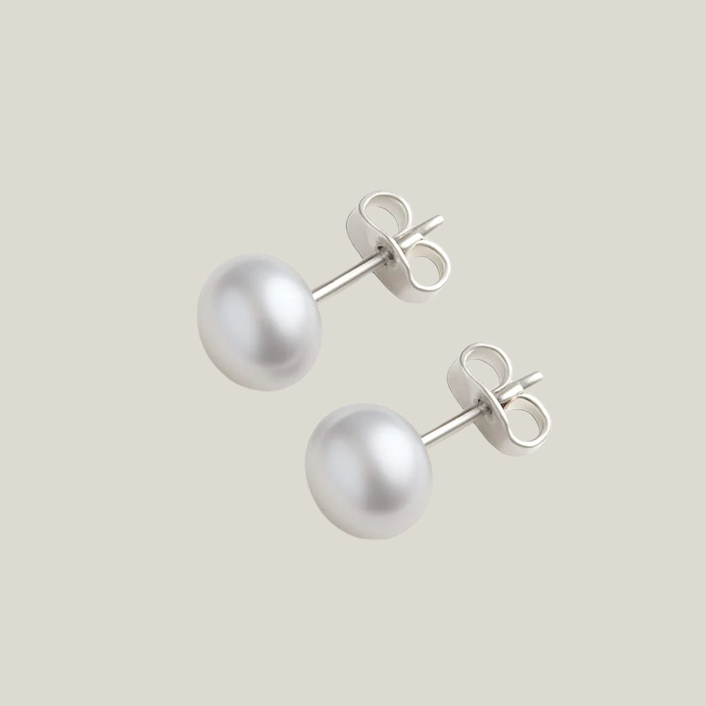Pair of pearl stud earrings on a white background